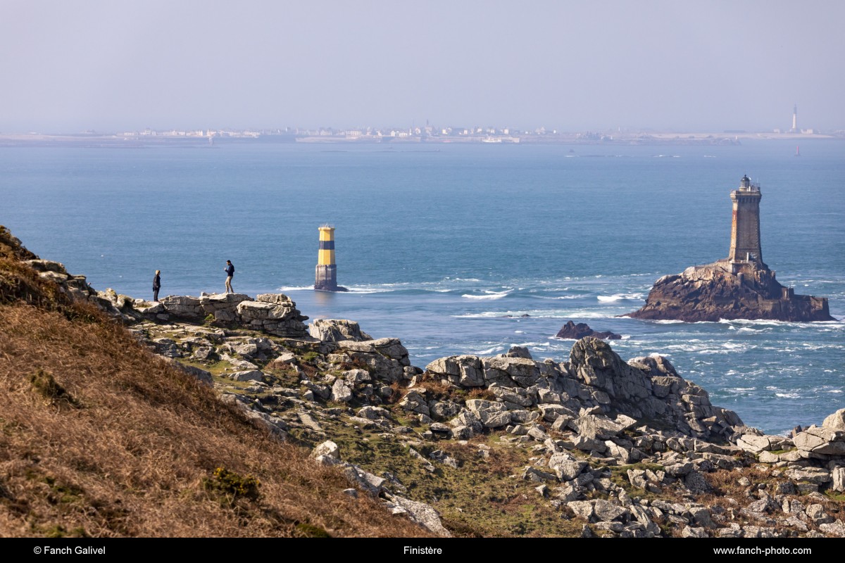 Promeneurs empreintant les sentiers de la pointe du Raz dans le finistère ( commune de Plogoff ). En arrière plan, on distingue le phare de la Vieille situé entre la pointe du Raz et l'ile de Sein.***Walkers on the trails of the Pointe du Raz in Finistère