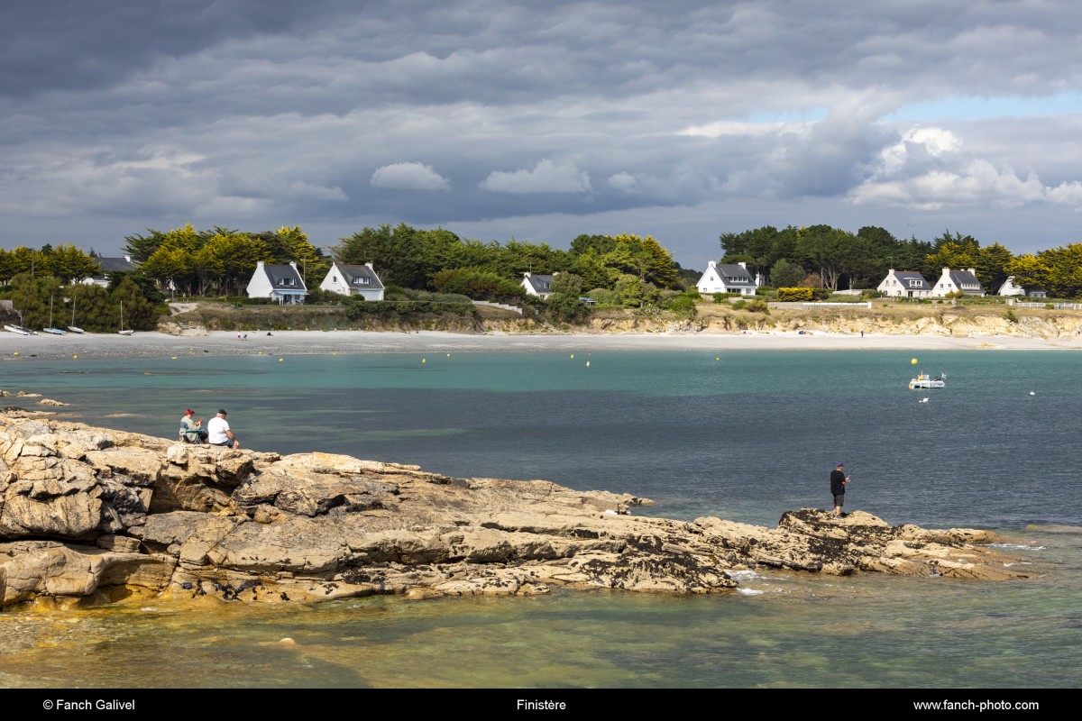 Pêcheur sur la pointe de Kerjean sur la commune de Trégunc. En arrière-plan, la plage de Kersidan***Fisherman on the tip of Kerjean in the town of Trégunc. In the background, the beach of Kersidan.