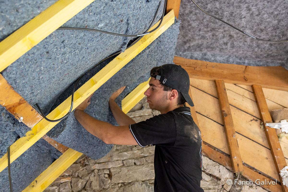 Travaux d’isolation par l’intérieur réalisés par l'entreprise Ty’iso à Camors. Placage d’une laine de coton en 2 couches croisées sur les rampants.