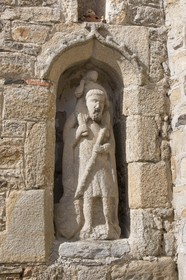 La statue de Saint-Christophe à Saint-Jacut de la Mer ( 22 ). Statue monolithe en granite abritée sous une niche aménagée dans le mur antérieur d'une maison, représentant saint Christophe portant l'enfant Jésus sur ses épaules, tenant dans sa main droite le pied du Christ et dans sa main gauche un bâton feuillu dont la partie basse est accompagnée d'un écu scutiforme armorié (probablement trois merlettes).