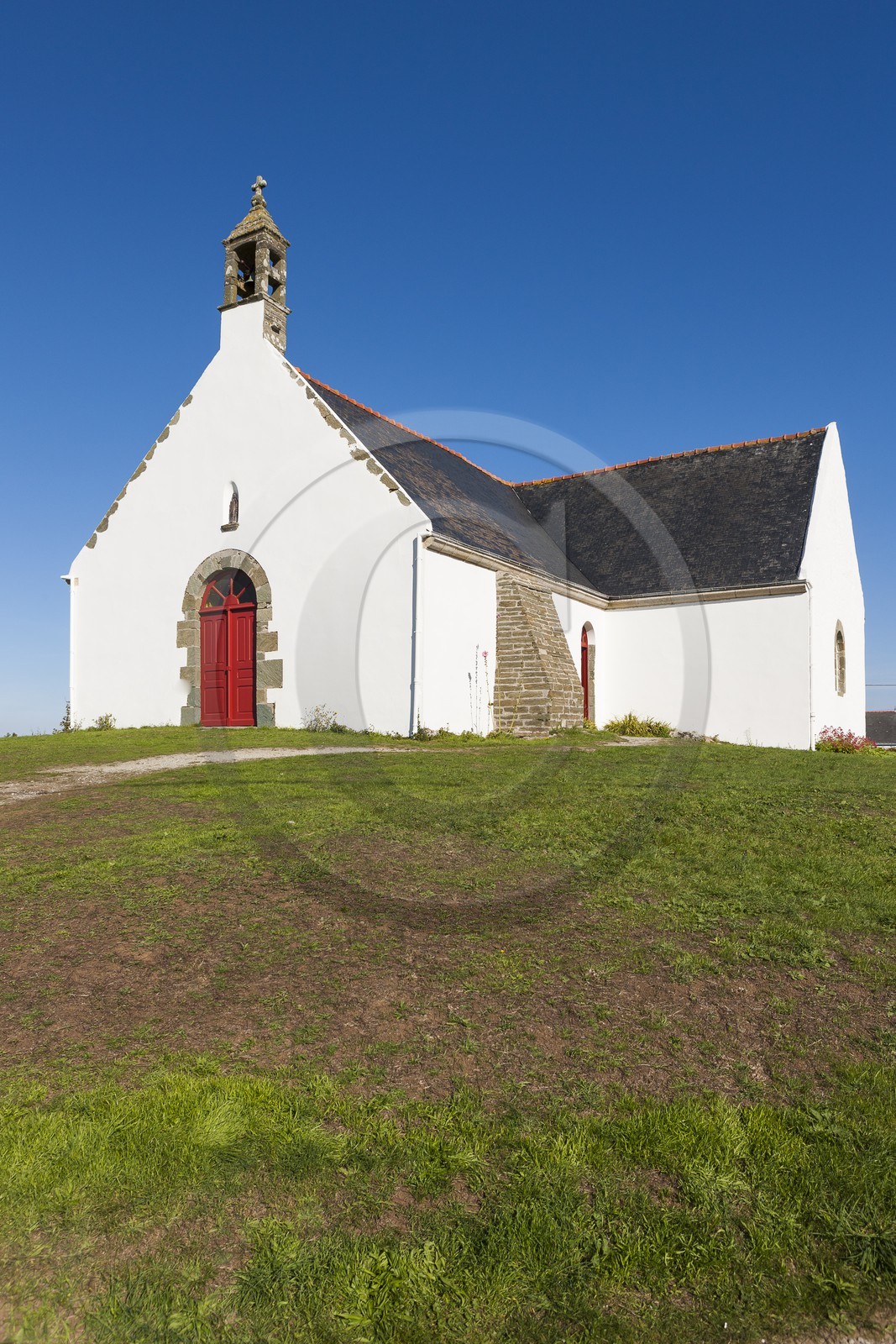 Ile de Groix _ Une famille, assise sur l' herbe, pique-nique devant la Chapelle de Quelhuit par une belle journée d' été _Island of Groix _ A family sitting on the grass, picnic at the Chapel of Quelhuit on a beautiful summer day