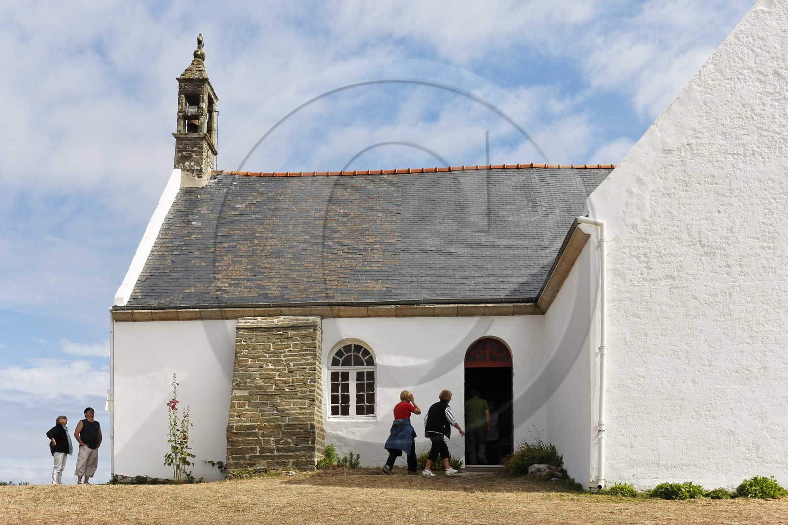 Groix _ Touristes visitant la Chapelle de Quelhuit sur l' ile de Groix. Tourists visiting the Chapel of Quelhuit on the island of Groix.
