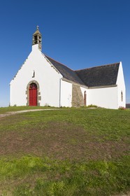 Ile de Groix _ Une famille, assise sur l' herbe, pique-nique devant la Chapelle de Quelhuit par une belle journée d' été _Island of Groix _ A family sitting on the grass, picnic at the Chapel of Quelhuit on a beautiful summer day